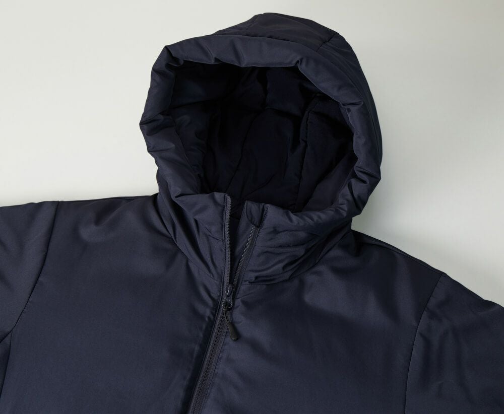 脱いだりかぶったりしやすい大きめの中綿入りフード、首もとは風の侵入を防ぐハイネック仕様 チンガード付き